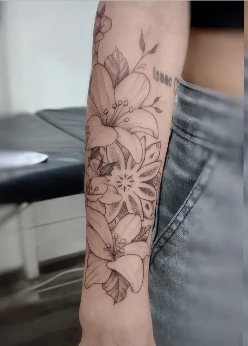 Lirios y mandala en línea fina tatuados a lo largo del antebrazo