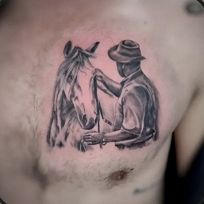 Hombre con sombrero junto a su caballo en realismo black & grey, tatuado en el pecho
