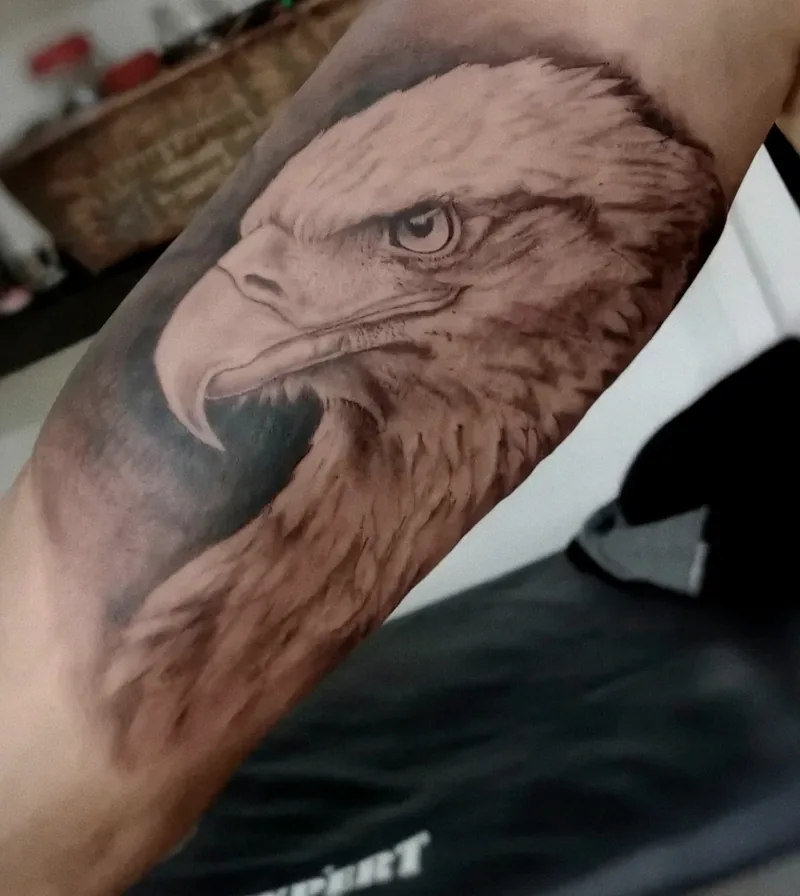 Cabeza de águila realista en black & grey tatuada en el brazo