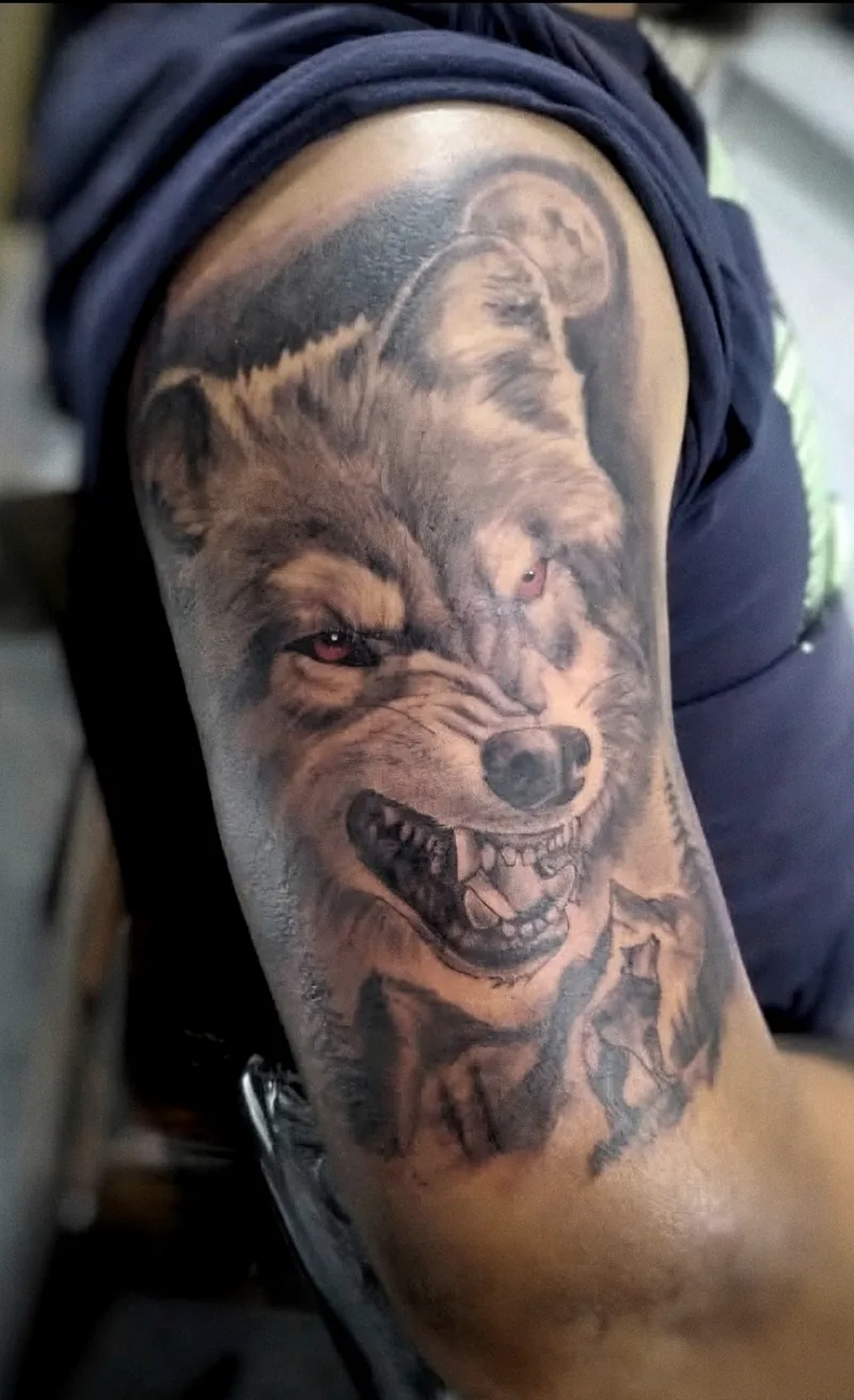 Lobo gruñendo en realismo black & grey, tatuado en el brazo