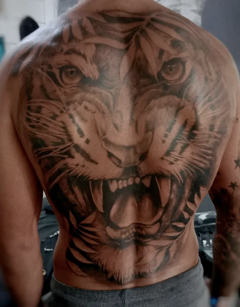 Tatuaje realista de un tigre rugiendo que cubre toda la espalda, en black & grey